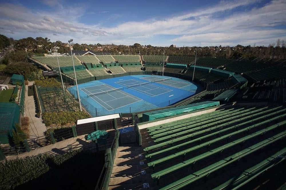 The centre court and green grandstand seating at Kooyong Stadium under a blue sky